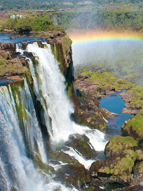 See a dazzling rainbow over the world's largest waterfall, Iguazú Falls